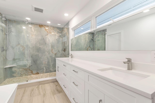 bathroom with hardwood / wood-style floors, vanity, and a tub