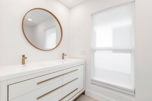 bathroom featuring hardwood / wood-style flooring, vanity, and walk in shower