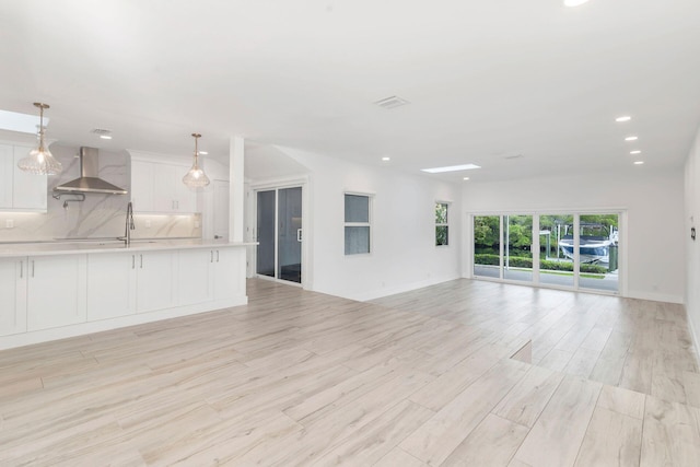 unfurnished living room featuring light wood-type flooring and sink