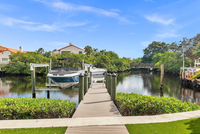 view of dock with a yard and a water view