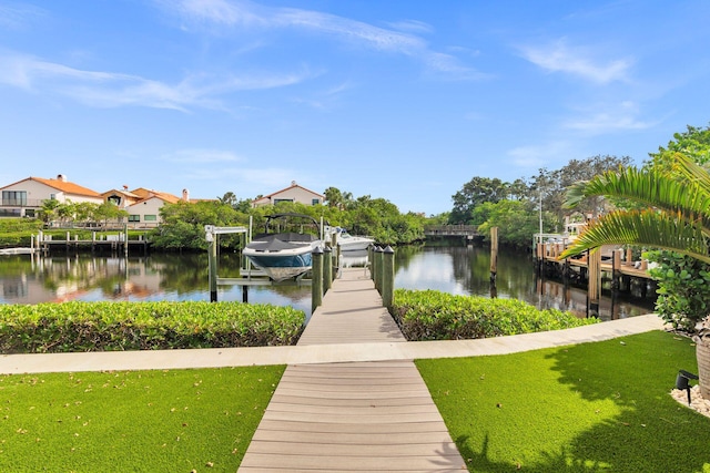 view of dock featuring a lawn and a water view