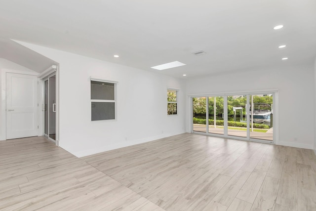 unfurnished room with a skylight, light hardwood / wood-style flooring, and a healthy amount of sunlight