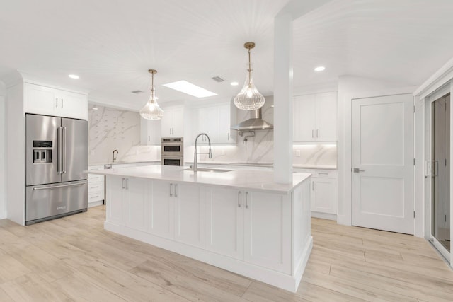 kitchen with tasteful backsplash, stainless steel appliances, sink, white cabinets, and a large island