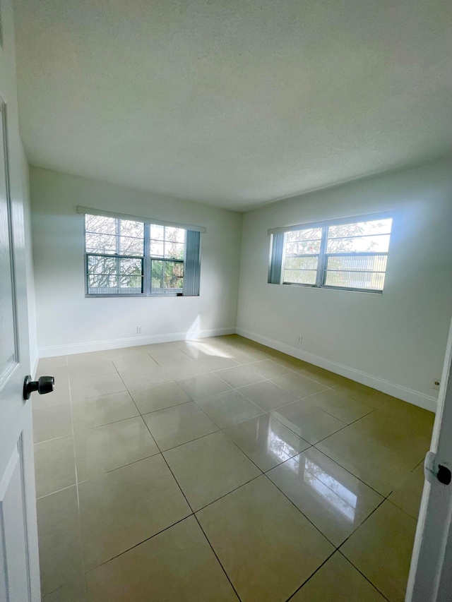 tiled spare room with plenty of natural light