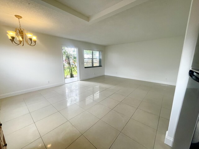 empty room featuring a textured ceiling and light tile patterned floors