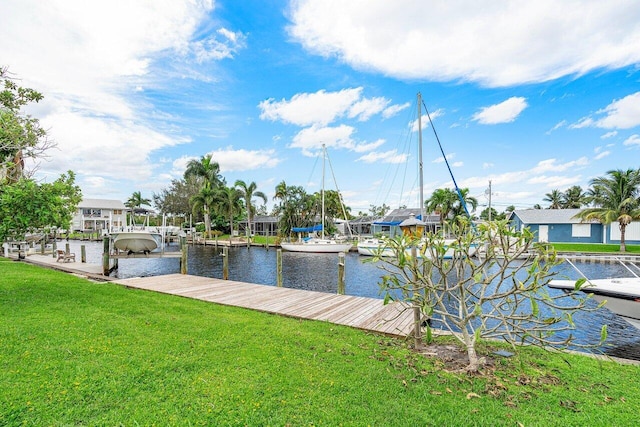 view of dock with a lawn and a water view