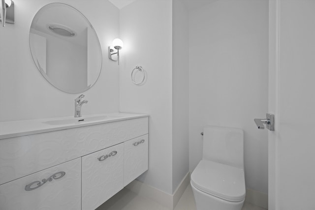 bathroom featuring toilet, vanity, and tile patterned flooring