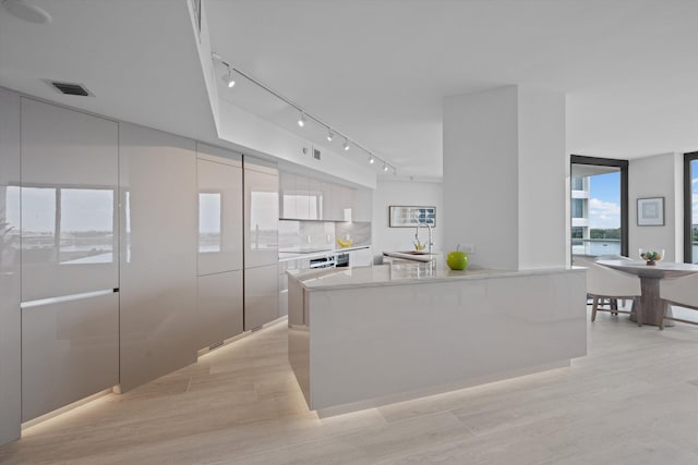 kitchen featuring light hardwood / wood-style flooring, white cabinets, sink, and a kitchen island