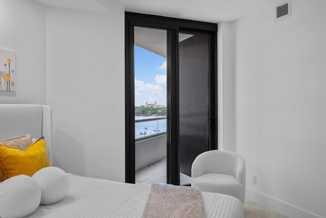 tiled bedroom with expansive windows and a water view