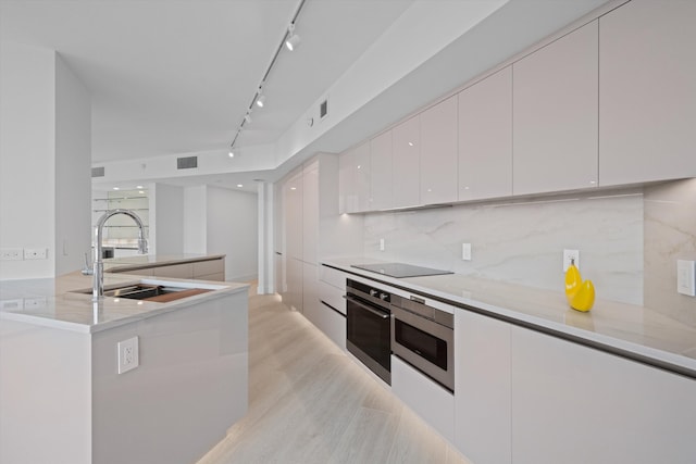 kitchen featuring backsplash, stainless steel appliances, sink, and white cabinets