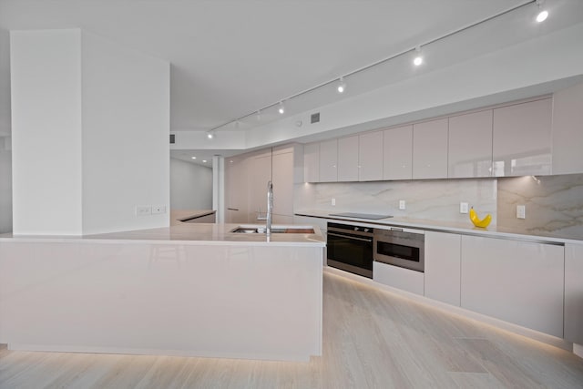 kitchen featuring oven, sink, and white cabinets