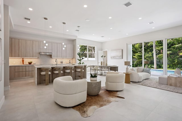 living room featuring sink and light tile patterned flooring