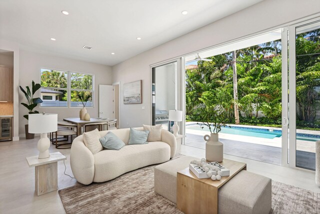 living room with beverage cooler and recessed lighting