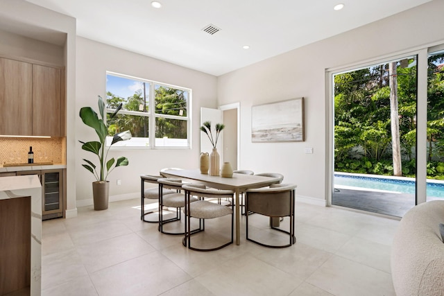 dining space featuring recessed lighting, baseboards, beverage cooler, and light tile patterned flooring