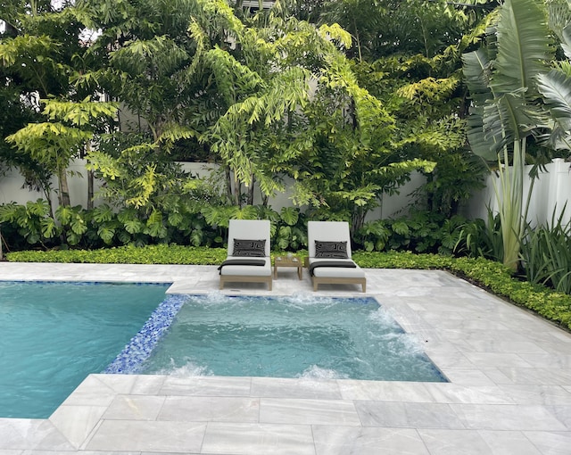 view of pool featuring a fenced backyard, a patio, and a pool with connected hot tub