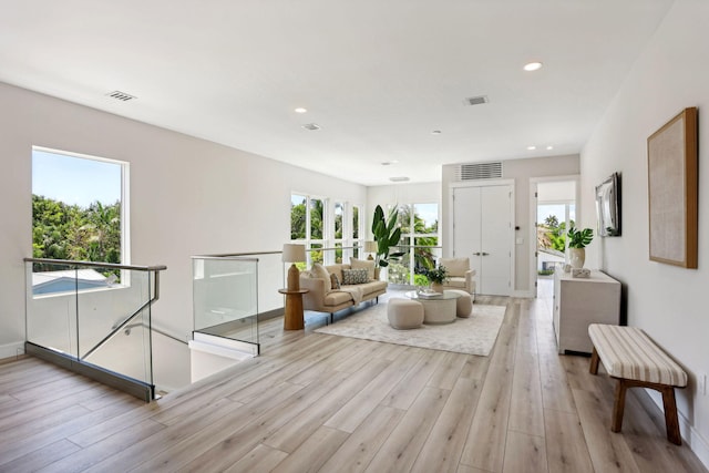 living room featuring light wood finished floors, recessed lighting, and baseboards