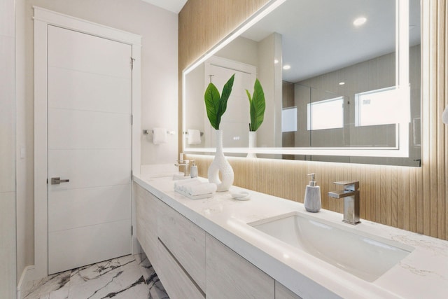 full bath with marble look tiles, double vanity, and recessed lighting