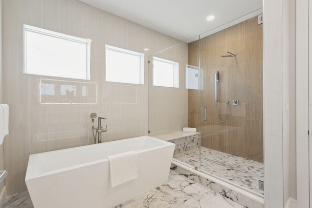 full bathroom featuring marble look tile flooring, a stall shower, a soaking tub, and recessed lighting