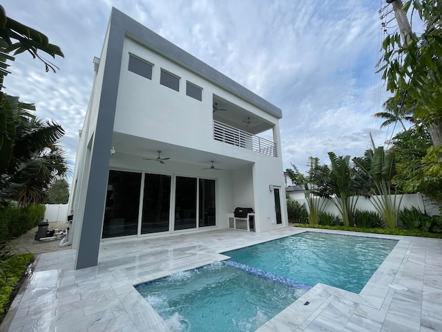 rear view of house with a balcony, a fenced in pool, ceiling fan, and a patio area