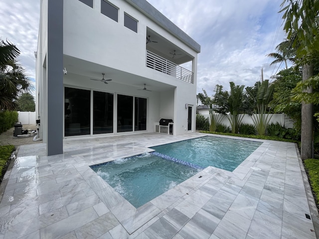 view of pool with a ceiling fan, a patio area, a pool with connected hot tub, and fence