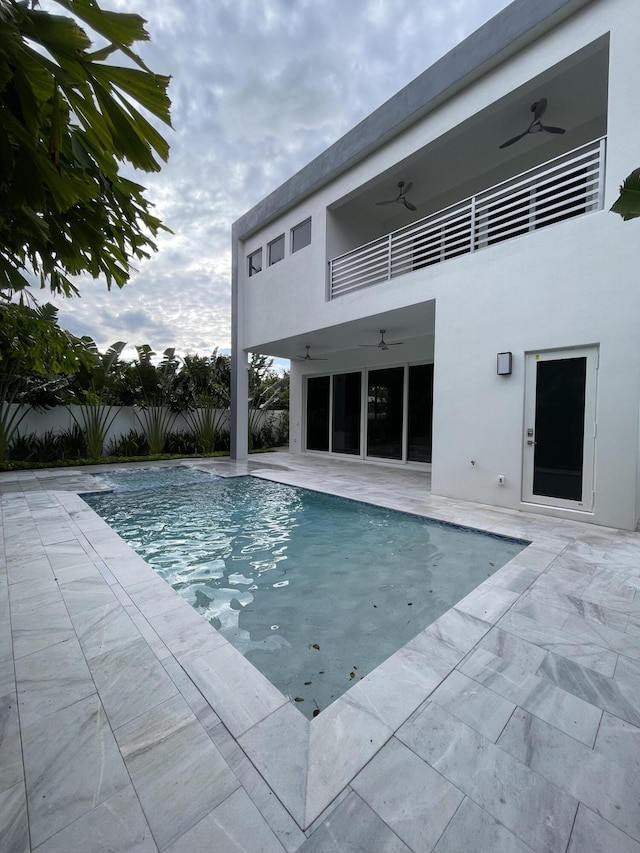 view of swimming pool with a ceiling fan, a patio, and fence