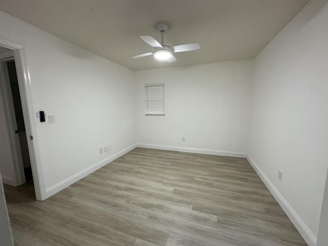 empty room with ceiling fan and light hardwood / wood-style flooring