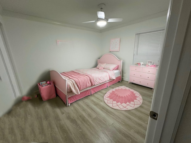 bedroom with ceiling fan, hardwood / wood-style flooring, and crown molding