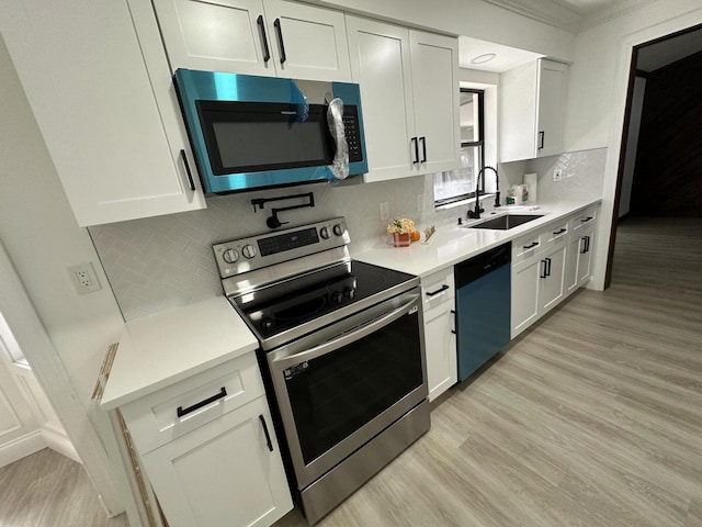 kitchen with white cabinets, appliances with stainless steel finishes, decorative backsplash, and sink