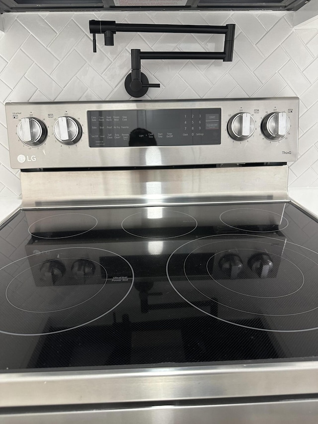 interior details featuring electric range and decorative backsplash