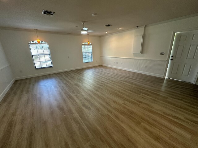 interior space with ceiling fan, crown molding, and dark wood-type flooring