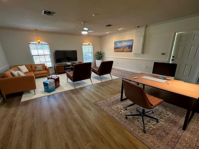 interior space with ornamental molding, ceiling fan, and light wood-type flooring