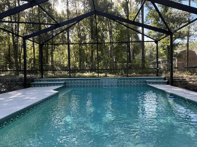 view of swimming pool featuring a lanai