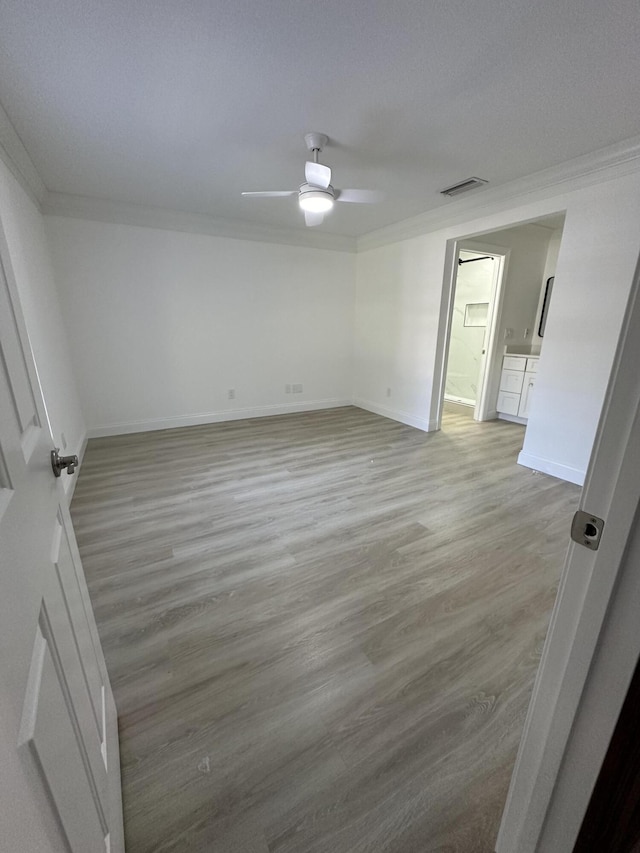 spare room featuring ornamental molding, ceiling fan, and light hardwood / wood-style flooring