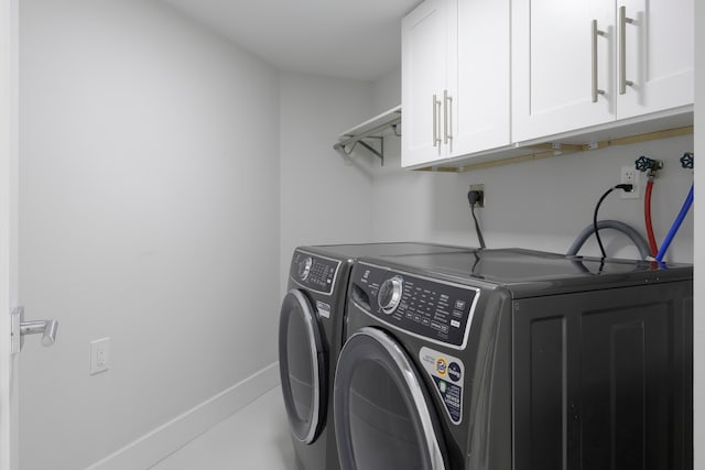 laundry area with washer and dryer and cabinets