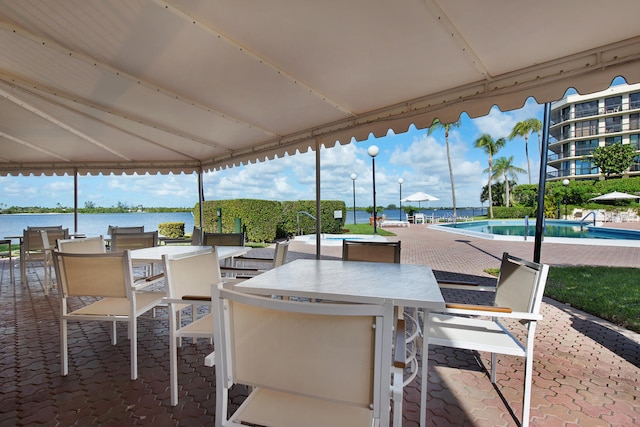 view of patio with a water view and a community pool