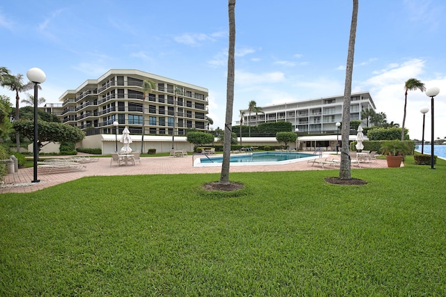 view of swimming pool with a patio area and a lawn