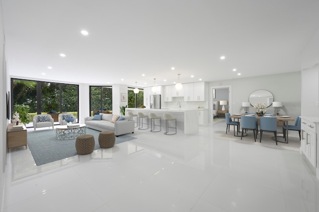 tiled living room featuring sink and floor to ceiling windows