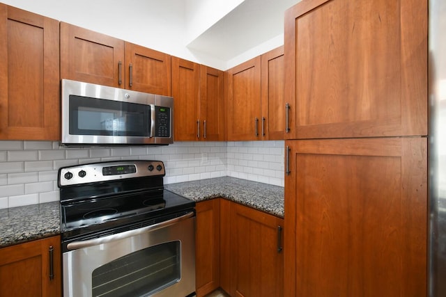 kitchen featuring decorative backsplash, dark stone countertops, and stainless steel appliances