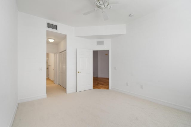 empty room with ceiling fan and light colored carpet