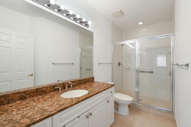 bathroom with tile patterned flooring, vanity, an enclosed shower, and toilet