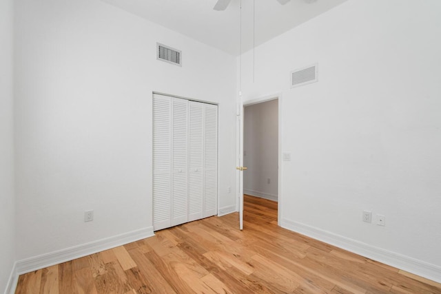 unfurnished bedroom with ceiling fan, light hardwood / wood-style floors, and a closet