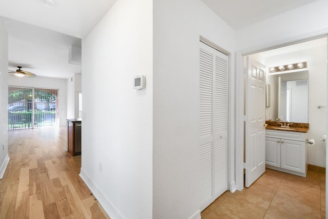 hallway featuring sink and light hardwood / wood-style flooring