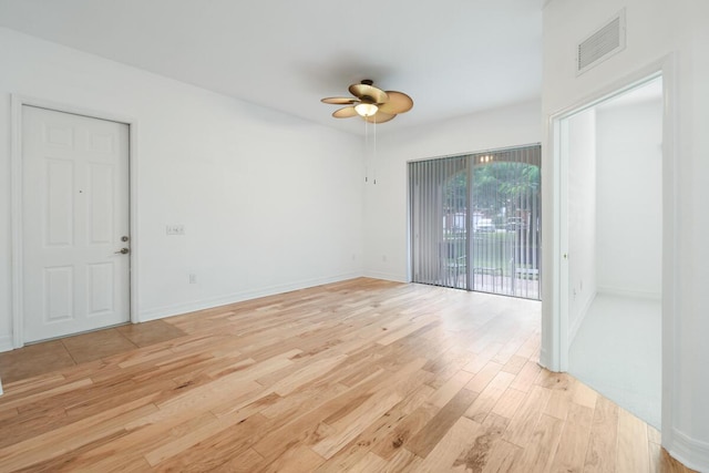 empty room with ceiling fan and light hardwood / wood-style flooring