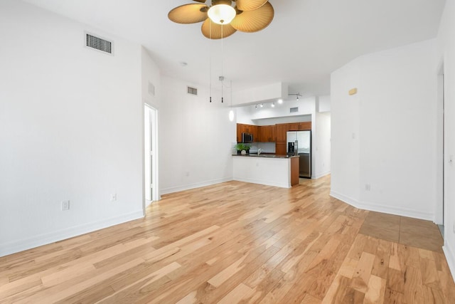 unfurnished living room featuring light hardwood / wood-style flooring and ceiling fan