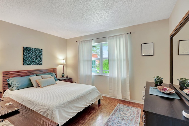 bedroom with parquet floors and a textured ceiling