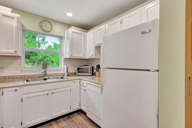 kitchen with sink, white cabinetry, light wood-type flooring, and white appliances