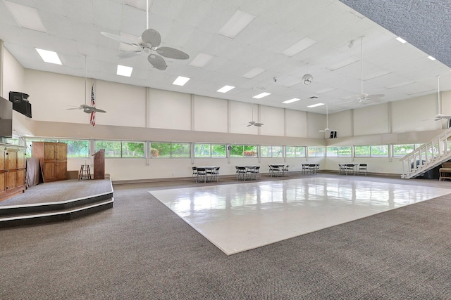 interior space featuring carpet floors, a healthy amount of sunlight, and a high ceiling