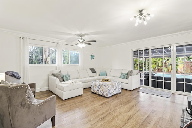 living room featuring crown molding, light hardwood / wood-style flooring, and ceiling fan