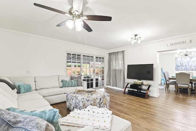 living room with ceiling fan with notable chandelier, ornamental molding, and hardwood / wood-style floors