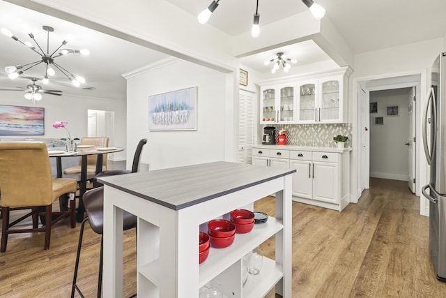 kitchen with backsplash, a chandelier, light hardwood / wood-style flooring, and white cabinets